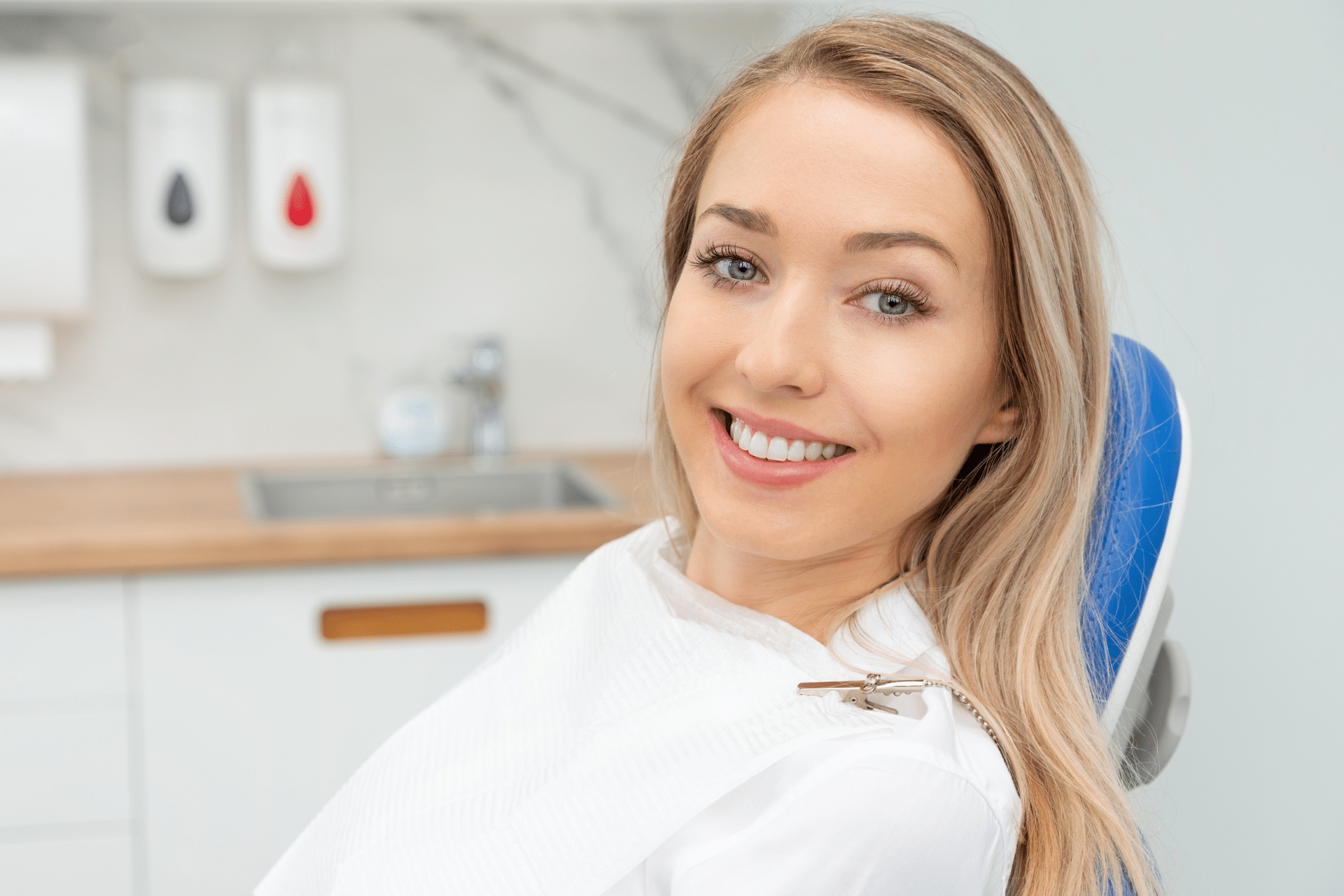 Smiling blonde woman sitting in a dental treatment chair